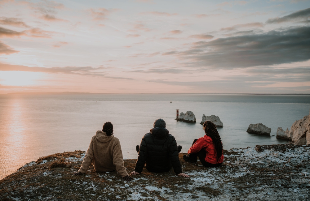 Group of friends sitting at a lookout of the ocean 