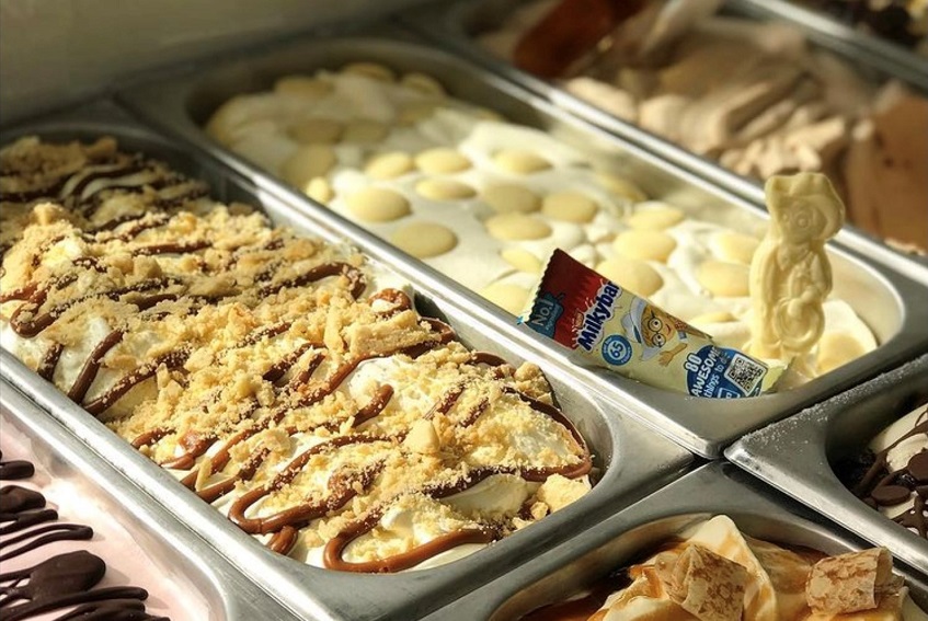 A close up of artisanal gelatos in metal containers