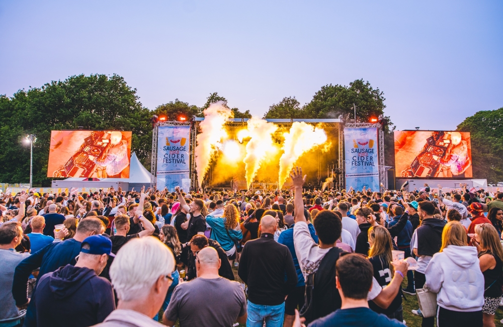 people gathered at a festival in front of a stage