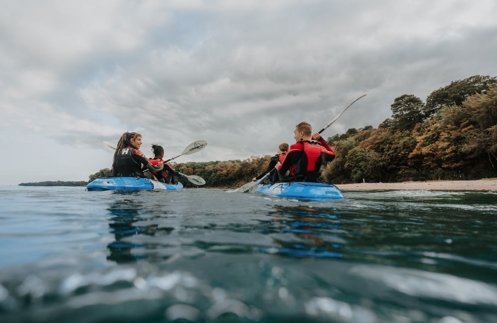 Group of friends on kayaks in the ocean