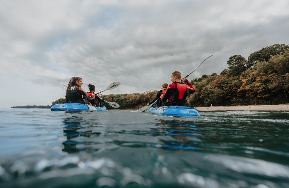 Group of friends on kayaks in the ocean 