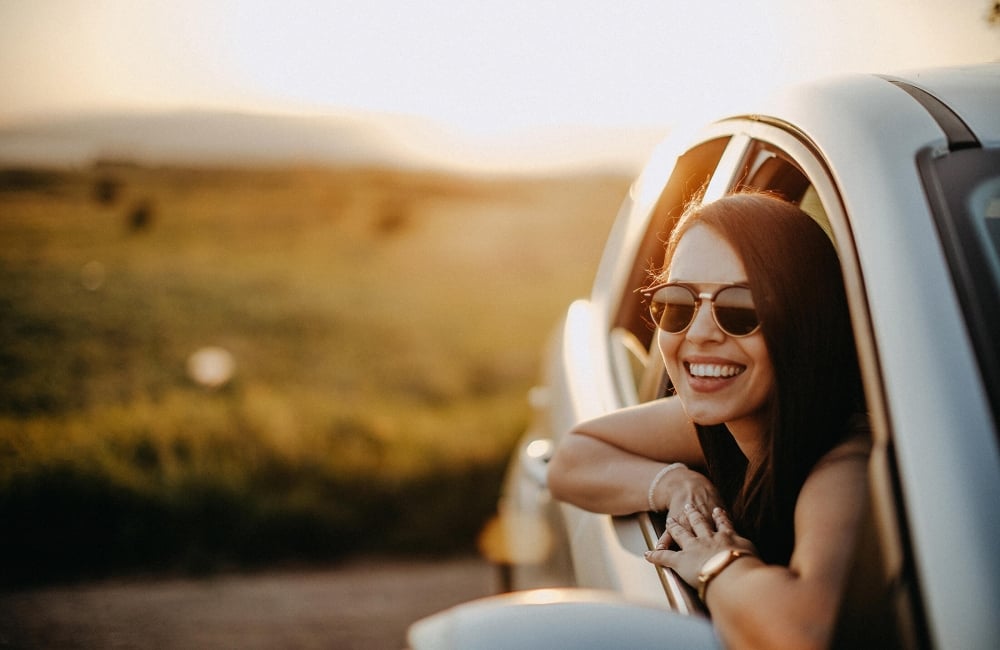 Women leaning out the window of her car