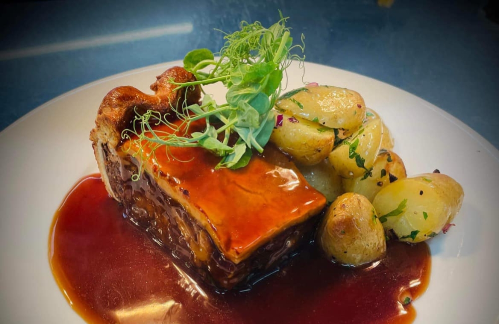 a plate with a slice of pie, potatoes and gravy