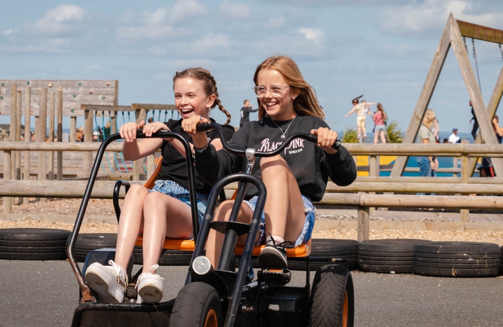 two children on go karts smiling