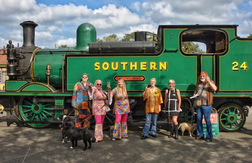 people pose by a train in 1960s fancy dress