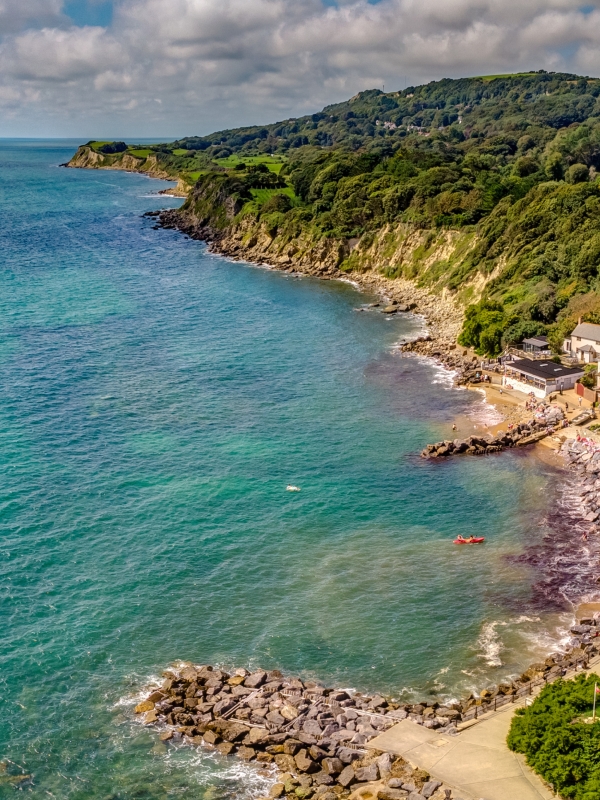 blue sea with stony beach taken from the sky