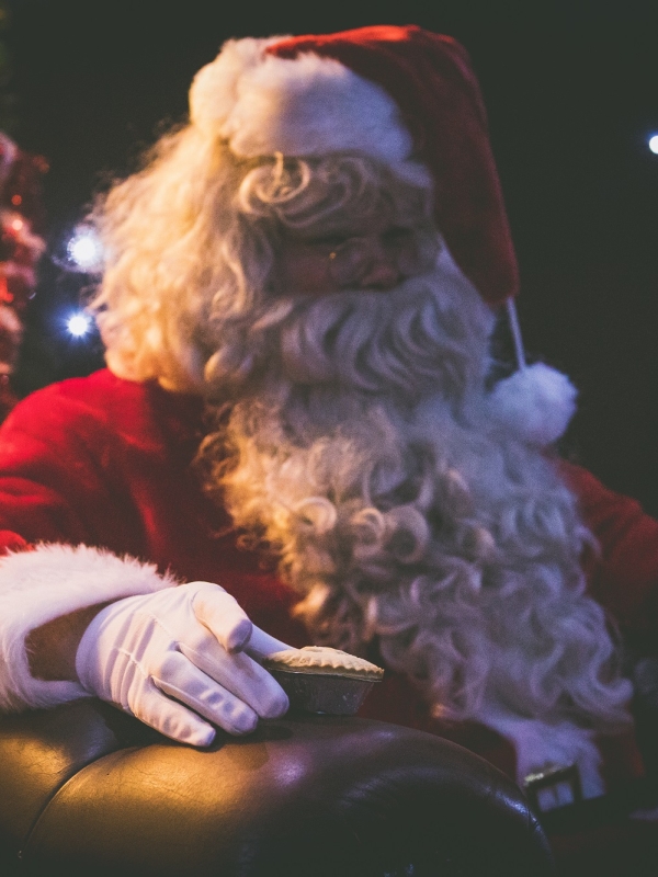 Santa sat in a chair in front of a Christmas tree