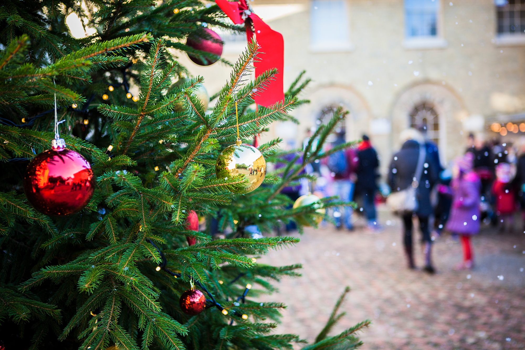 a christmas tree with red baubles and ribbons