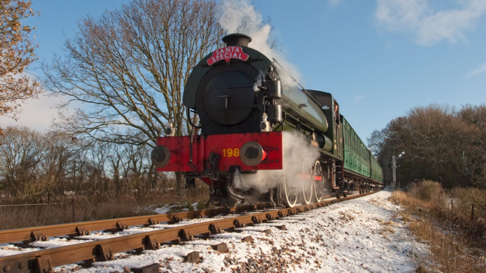steam locomotive moving through a snowy landscape 