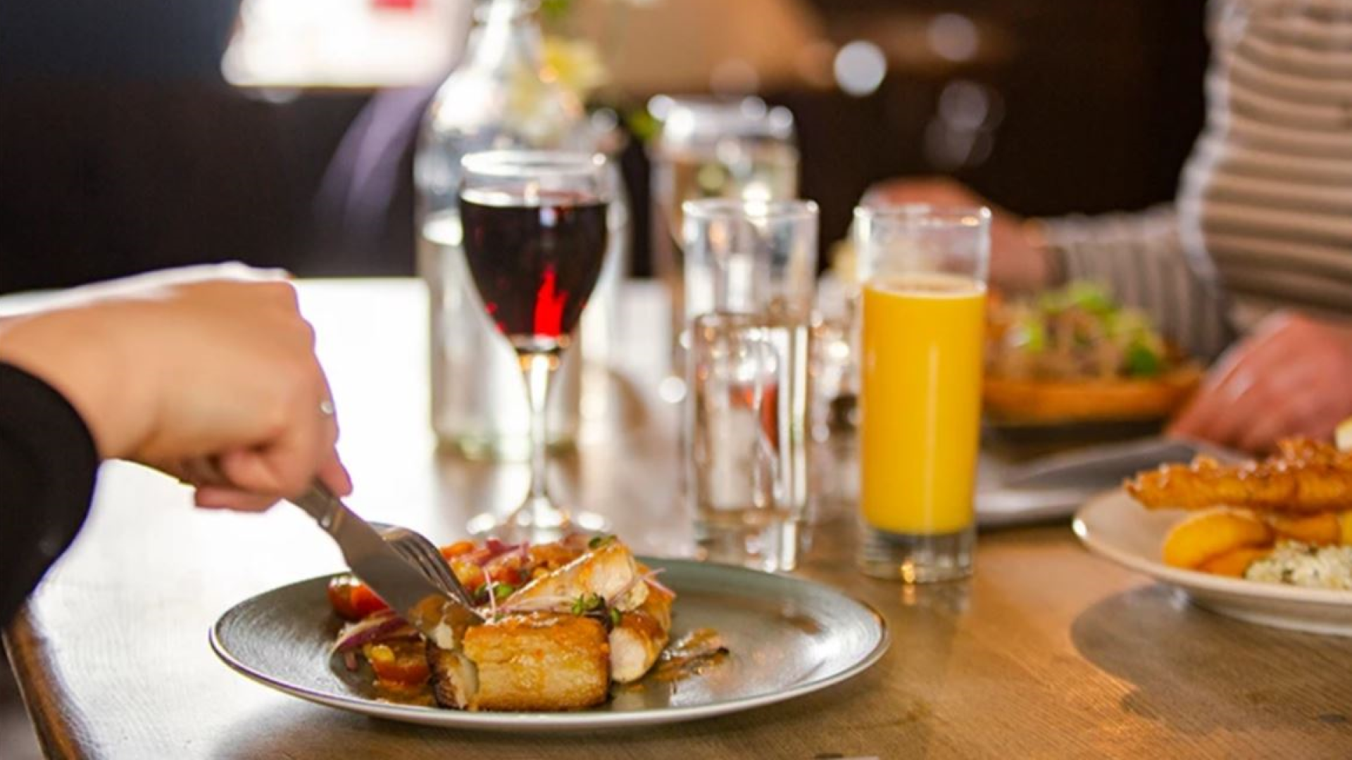 people enjoying food at a restaurant table