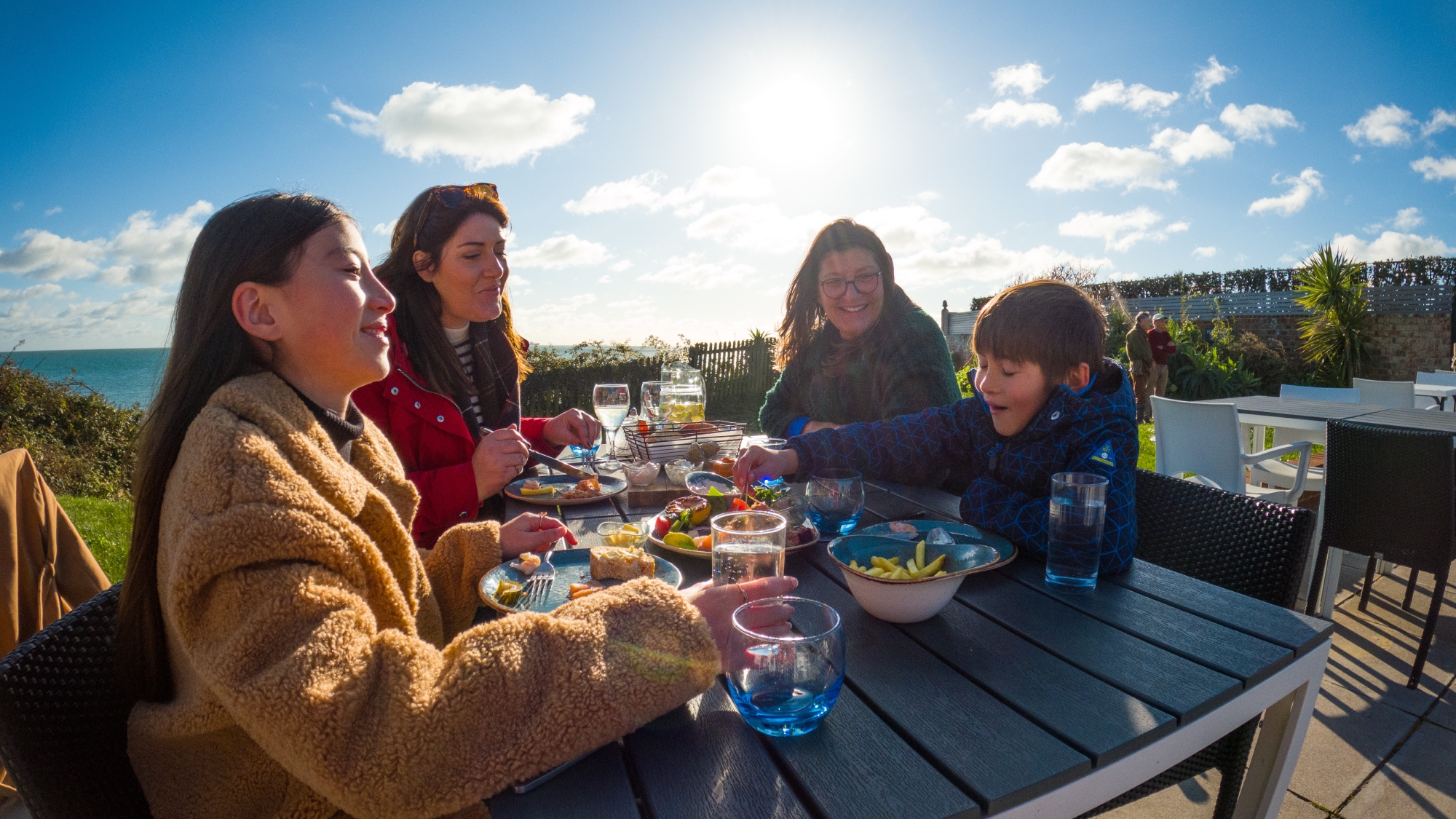 4 people sat outside eating food