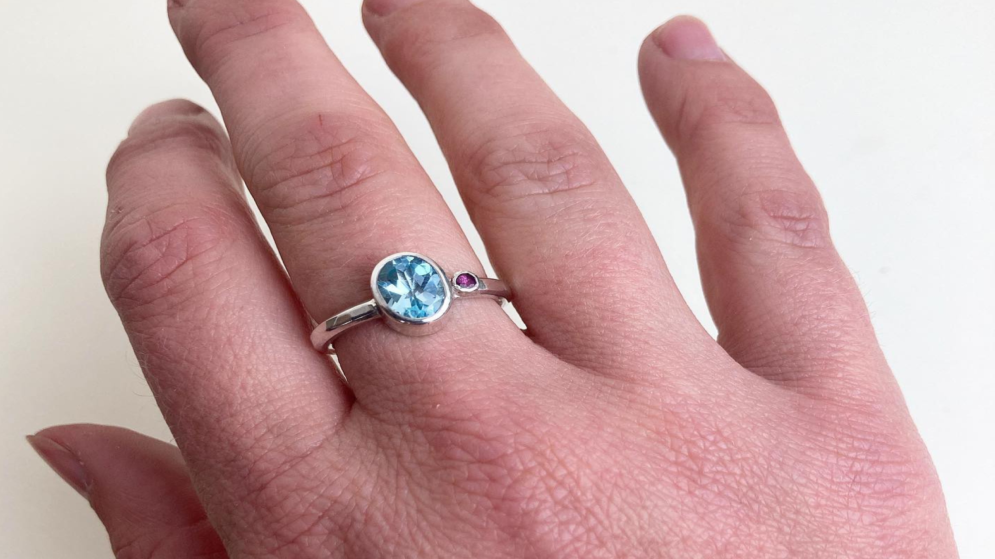 beautiful ring with a blue stone on models hand
