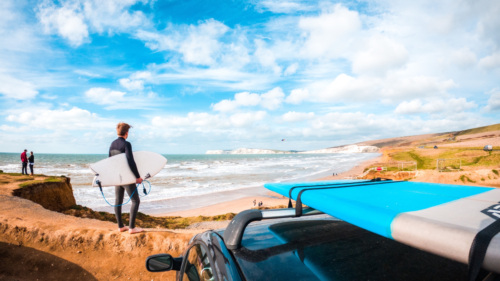 Person with surfboard looking out to sea