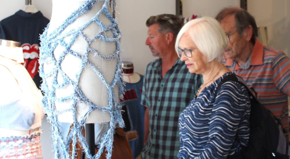 a woman admiring a handmade piece of clothing