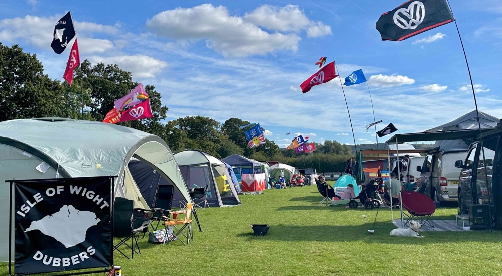 a campsite with tents and VW flags