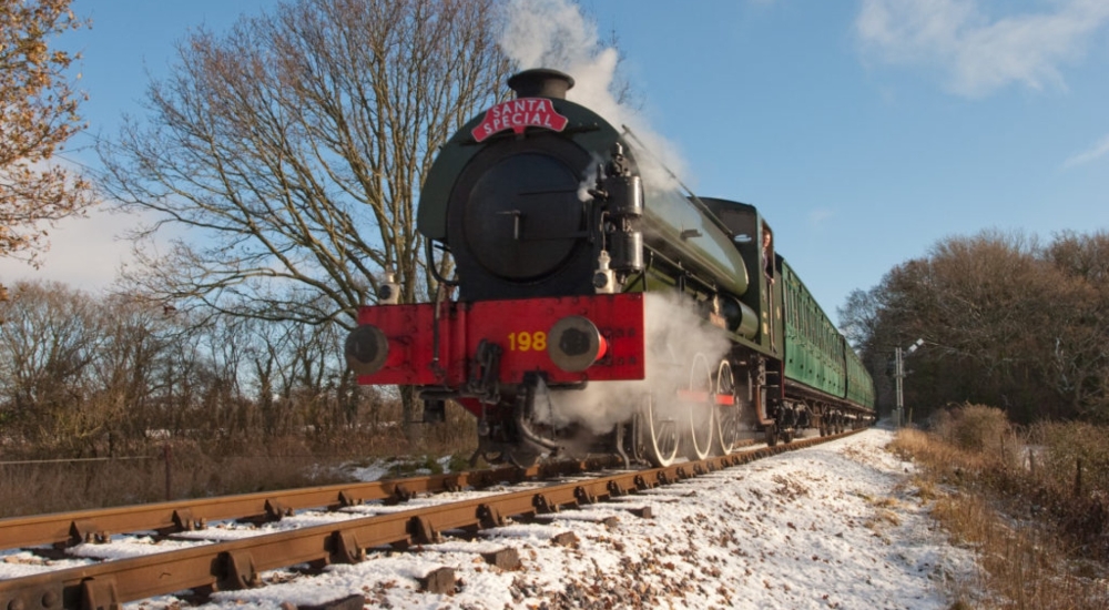 steam locomotive moving through a snowy landscape