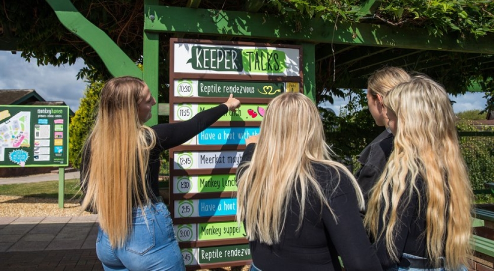 Visitors looking at the Keeper talks schedule sign