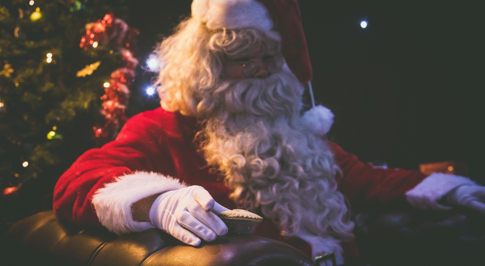 Santa sat in a chair in front of a Christmas tree