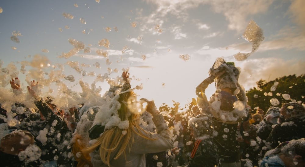 a crowd dancing at a foam party